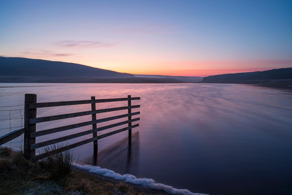 Winter light over water and a fence, photographed by Hugh Maxwell