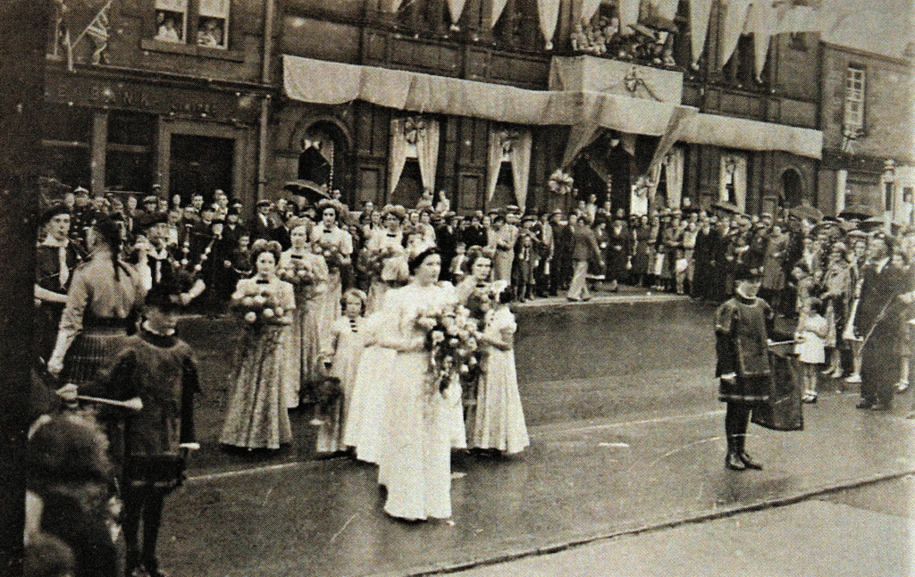 Eva Morton leading the 1939 Lace Queen procession through crowded Darvel streets